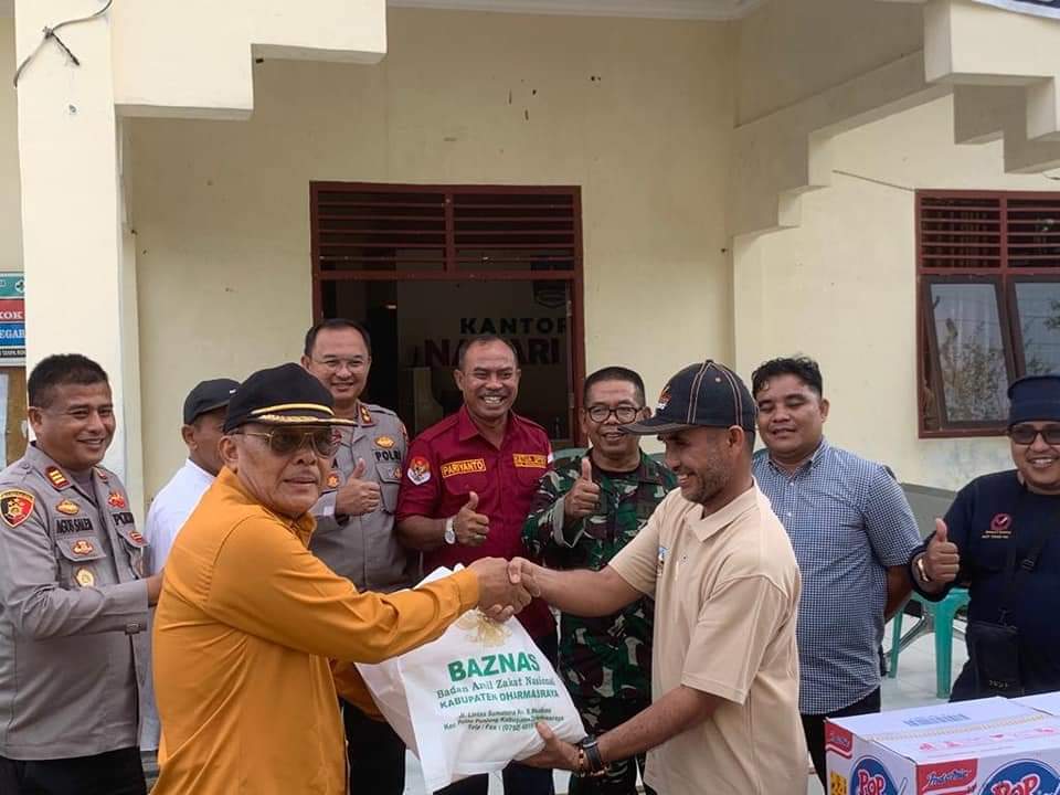 Ketua Baznas Dharmasraya Z. Lubis,S.Pd yang didampingi Forkopimda memberikan bantuan kepada salah seorang warga yang terdampak banjir di Kecamatan Timpeh, Jumat (10/03/23). (SP)